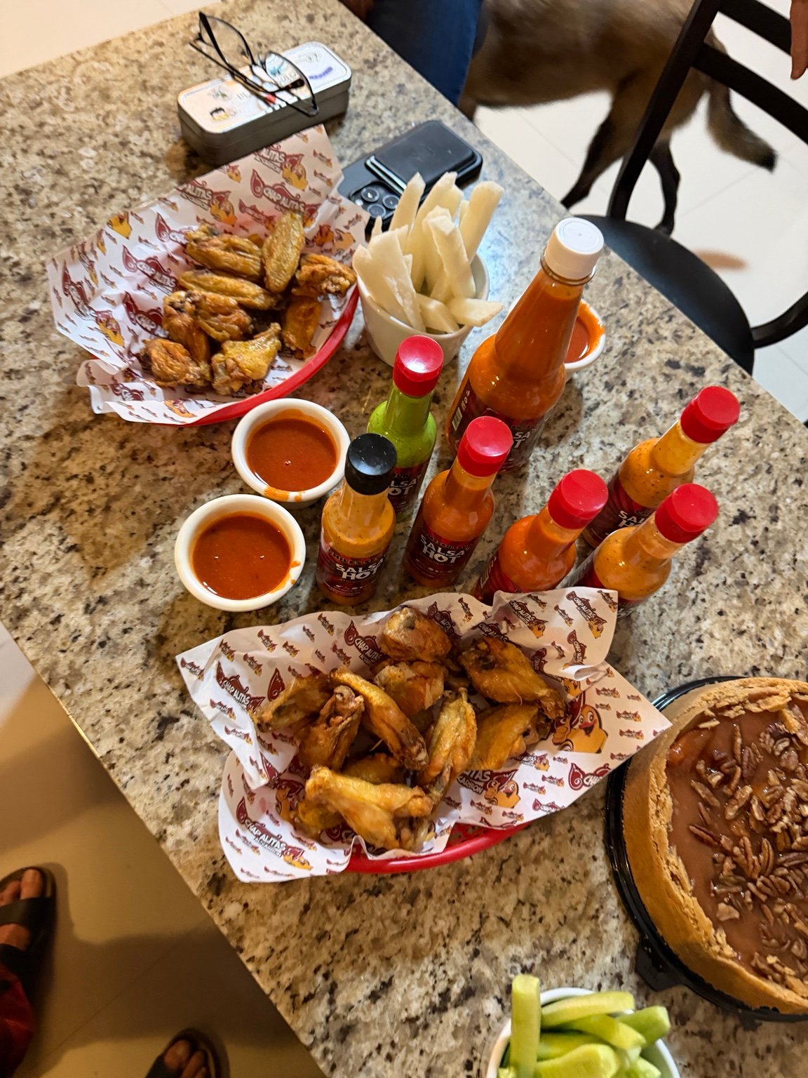 Alitas y botellas SalsaHot servidas en mesa
